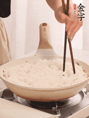 把瀝干水分的米飯均勻鋪在上面，筷子戳幾個(gè)洞，以便透氣，轉(zhuǎn)小火蓋上蓋子燜至水分收干，大概10分鐘。